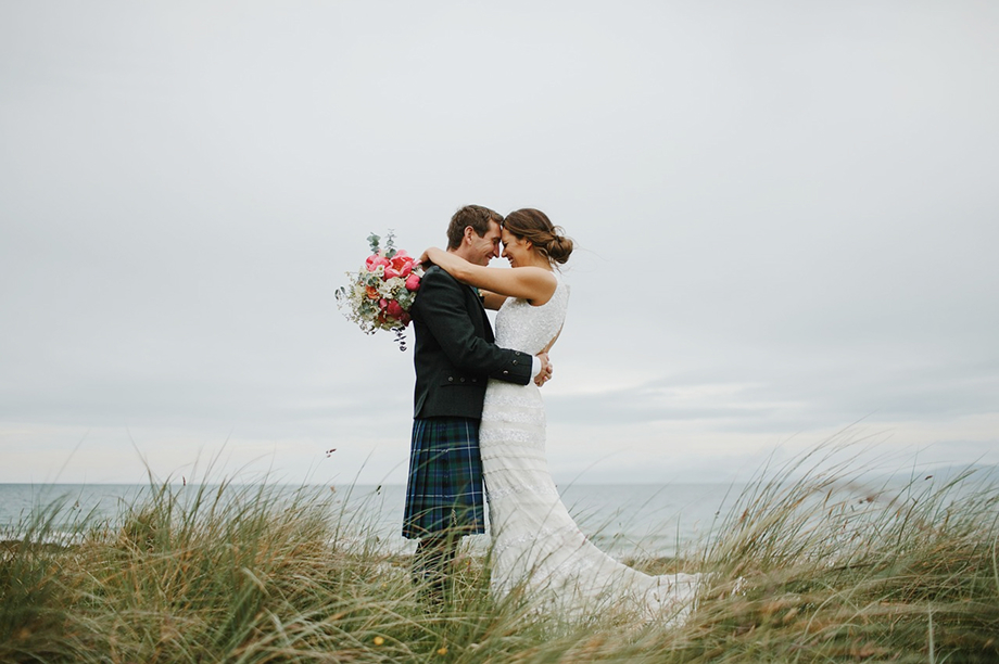 草原で抱き合う新郎新婦の画像